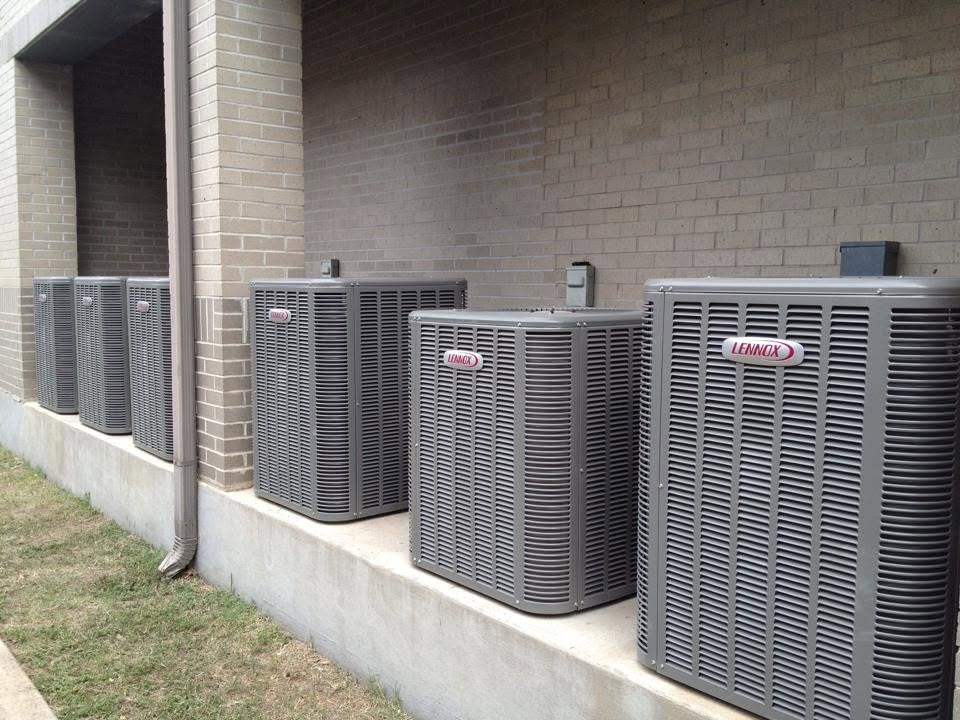 Row of Lennox commercial condensing units installed along a commercial building by Jessie's Air Service