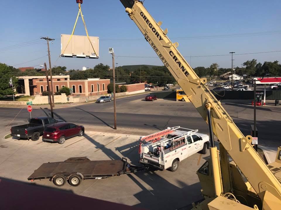 Crane lifting commercial rooftop HVAC unit during installation by Jessie's Air Service Stephenville TX